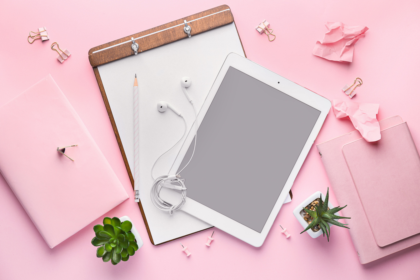 Tablet Computer with Stationery on Pink Background